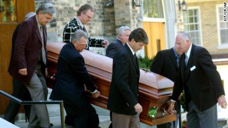 Pallbearers escort Canadian golf legend Norman's coffin.