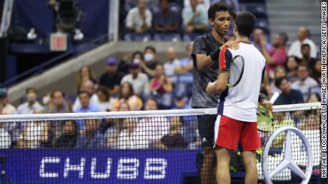 Felix Auger-Aliassime from Canada and Carlos Alcaraz from Spain meet at the net.
