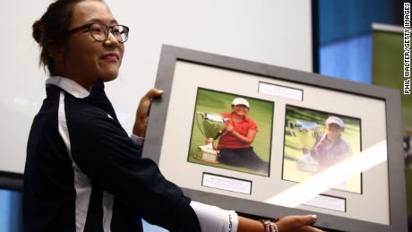 Ko is shown a photo board displaying her victories after arriving at Auckland International Airport on September 18, 2013 in New Zealand.