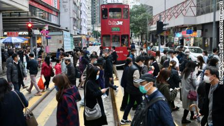 People in face masks cross a street in Hong Kong on December 21.