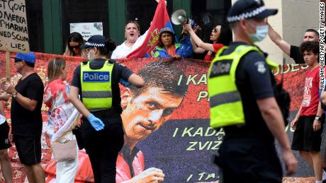 People hold signs outside the Park Hotel, where 20-time Grand Slam champion Novak Djokovic will be staying in Melbourne on January 7, 2022.