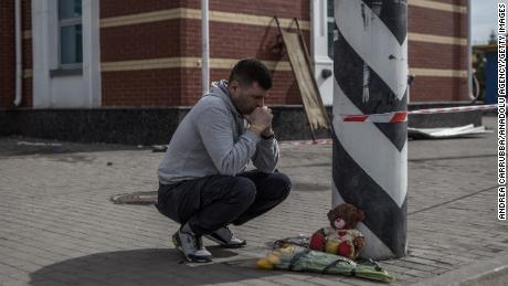 A man lays flowers at a memorial at Kramatorsk train station.