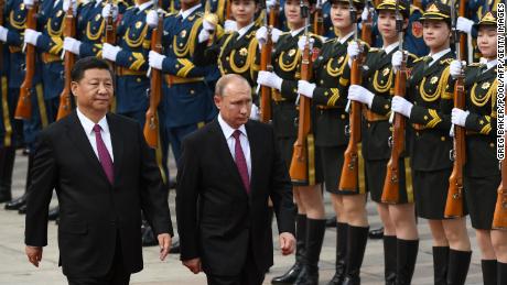 Chinese President Xi Jinping and Russian leader Vladimir Putin view a military honor guard outside the Great Hall of the People in Beijing on June 8, 2018. 