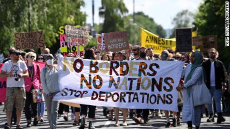 Protesters protest outside an airport fence against a planned deportation of asylum seekers from the UK to Rwanda, at Gatwick Airport on June 12, 2022.