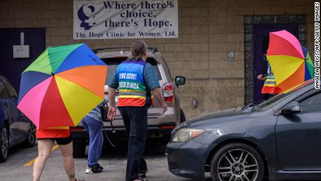 Volunteer clinic attendants protect a patient from anti-abortion protesters at the Hope Clinic For Women in Granite City, Illinois, on June 25, 2022. 