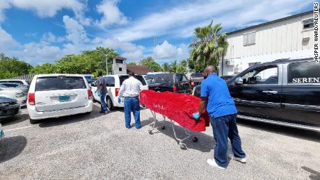 The body of one of the dead is disposed of by morgue workers in Nassau. 
