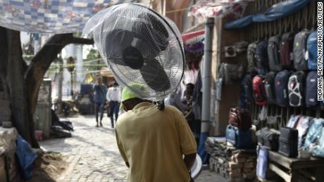 A man carries a foot fan amid a heat wave in Kolkata, India.