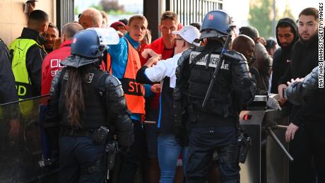 Police and stewards are seen as Liverpool fans queue outside the stadium ahead of the UEFA Champions League final match between Liverpool and Real Madrid at Stade de France on May 28 in Paris. 