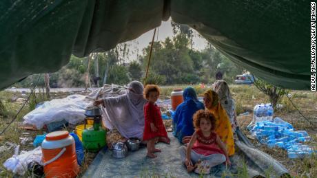 Displaced persons prepare for breakfast in their tents at a makeshift camp after fleeing their flood-stricken homes on August 29, 2022 after heavy monsoon rains in Khyber Pakhtunkhwa's Charsadda district.