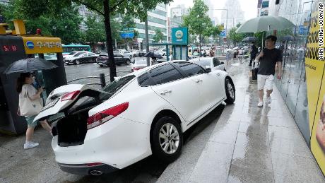 A vehicle is damaged on the sidewalk after it drifted in heavy rain in Seoul, South Korea, on Aug. 9.
