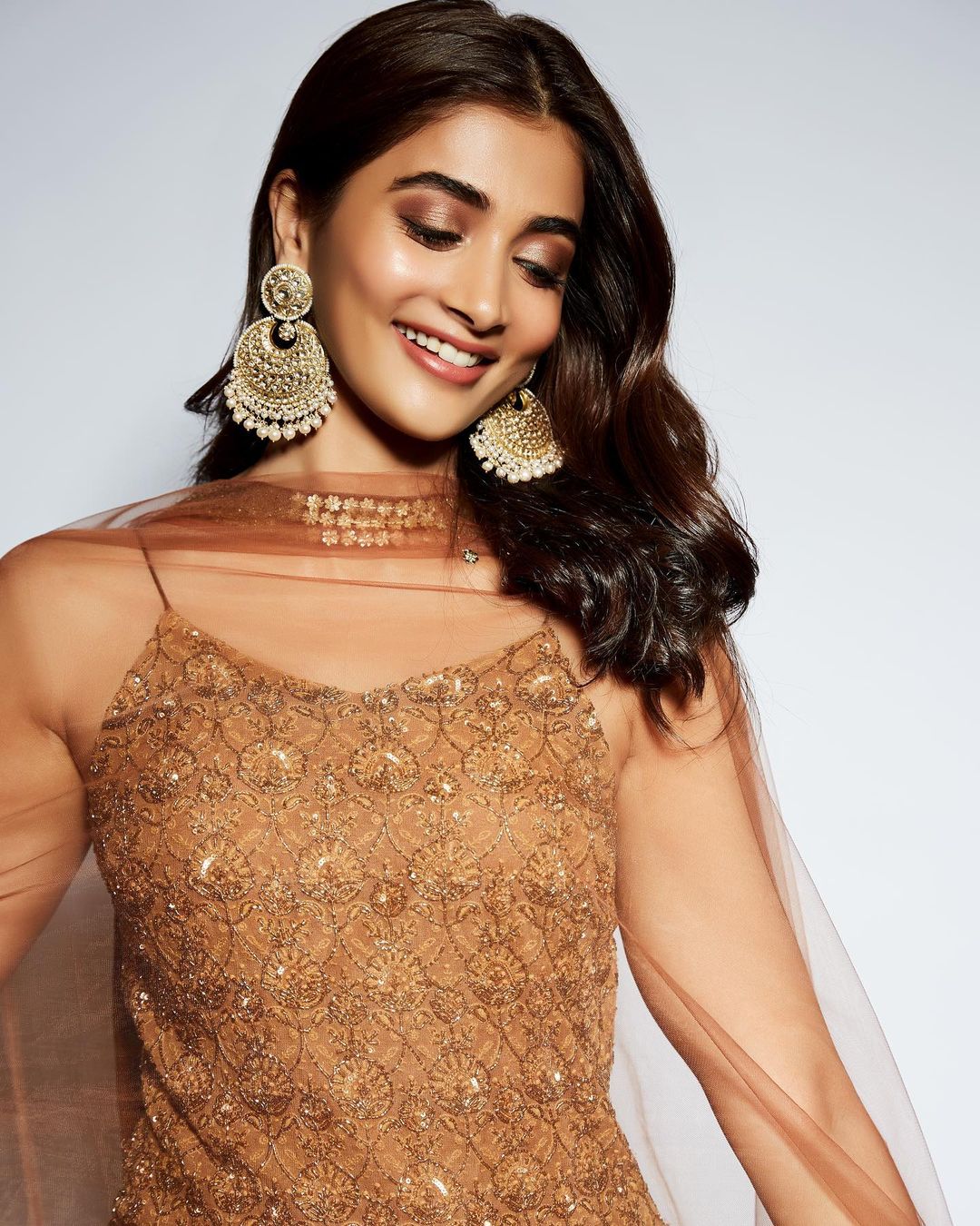 Pooja Hegde wears a pair of chandbaali earrings with the outfit.