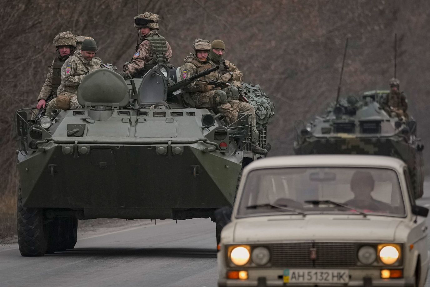 Ukrainian soldiers sit on armored vehicles driving in the Donetsk region of eastern Ukraine on Feb. 24. 
